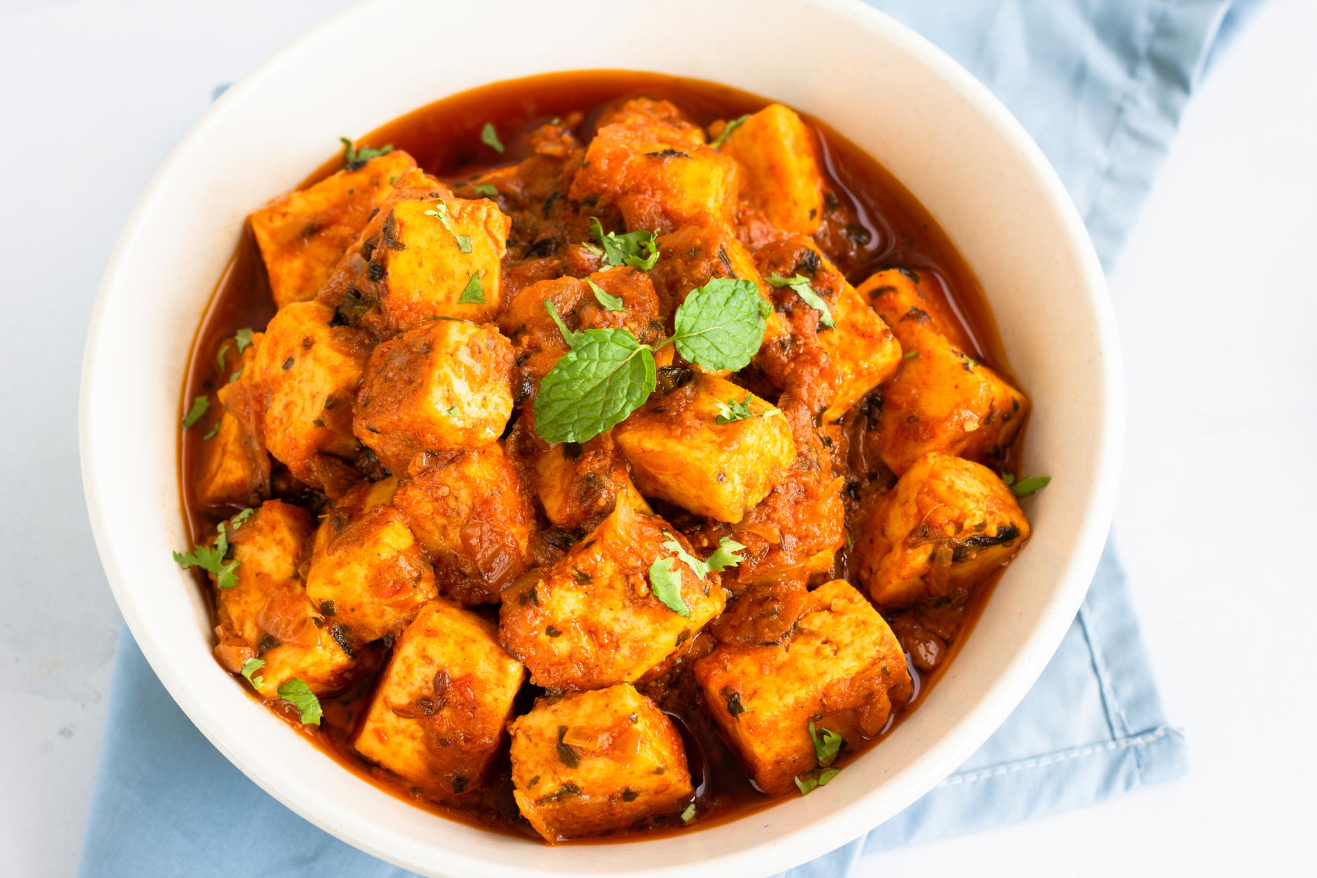 a bowl with indian red curry with tofu