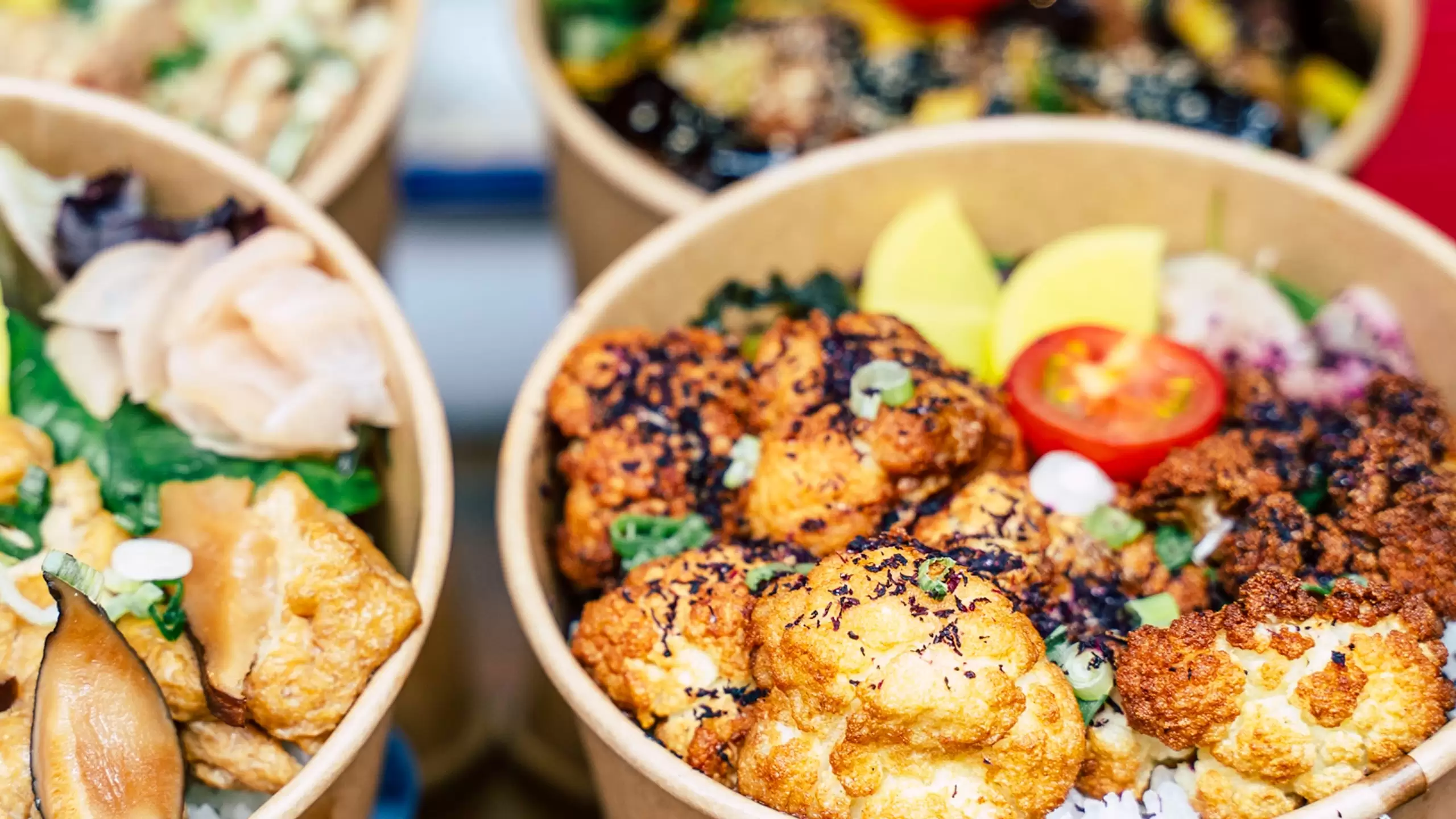 colorful vegan dishes in take out containers