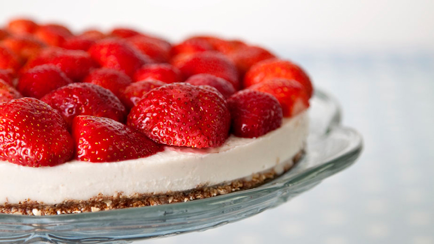 raw vanilla cream cake topped with fresh strawberries