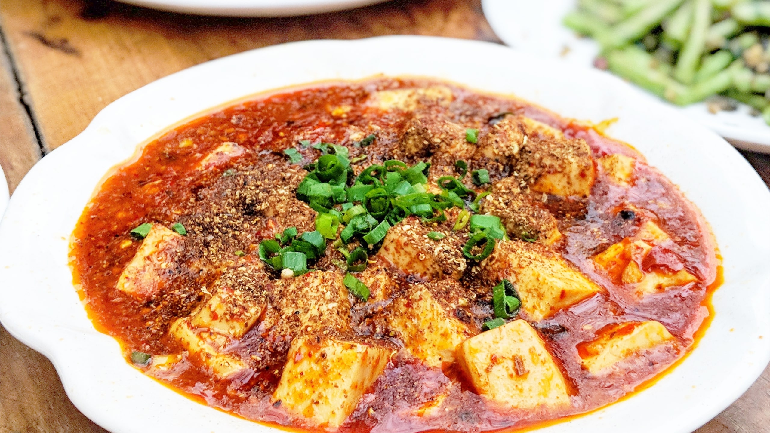 bowl with red ma po with tofu and greens