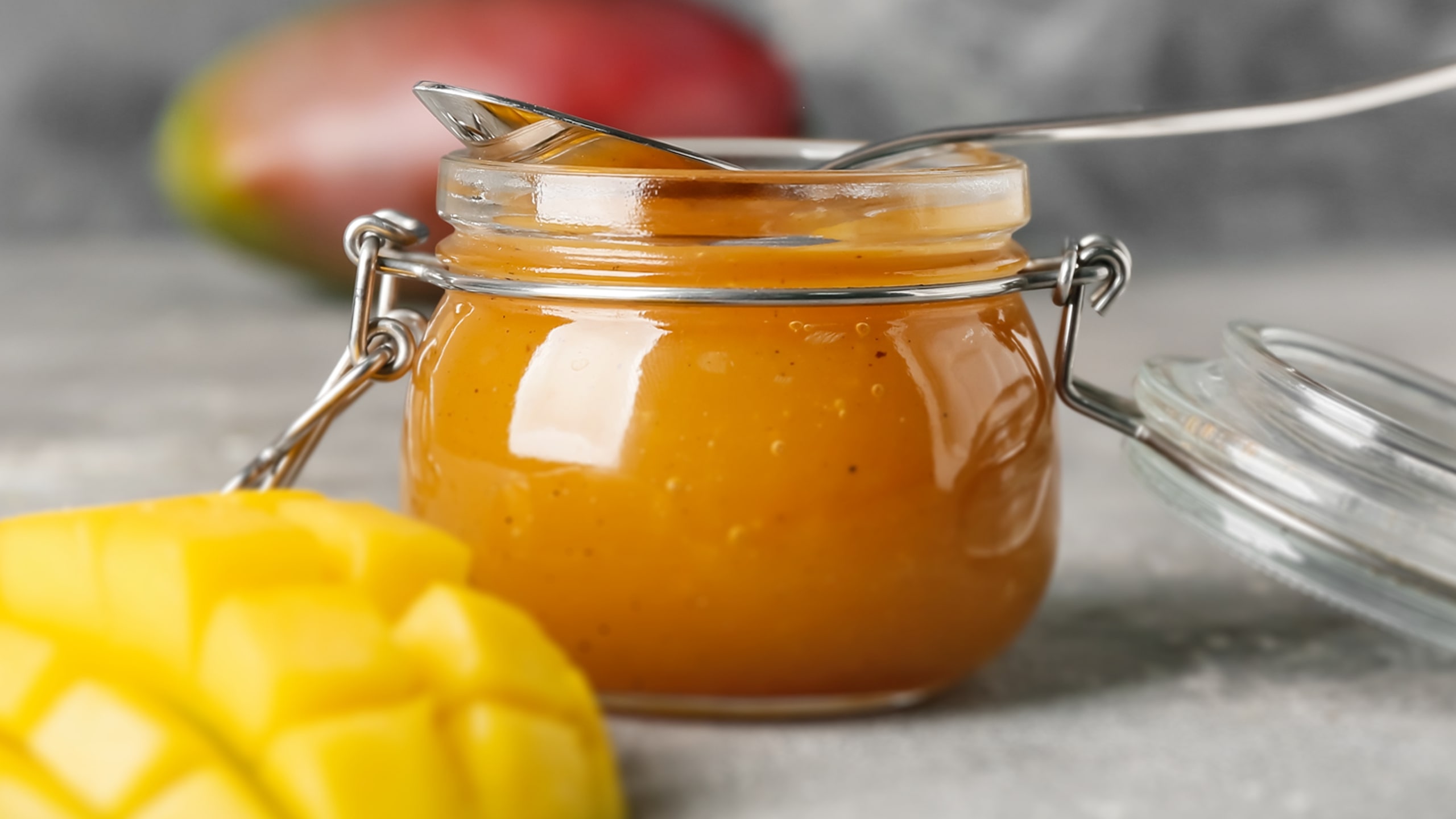 thick yellow mango sauce in a clear jar