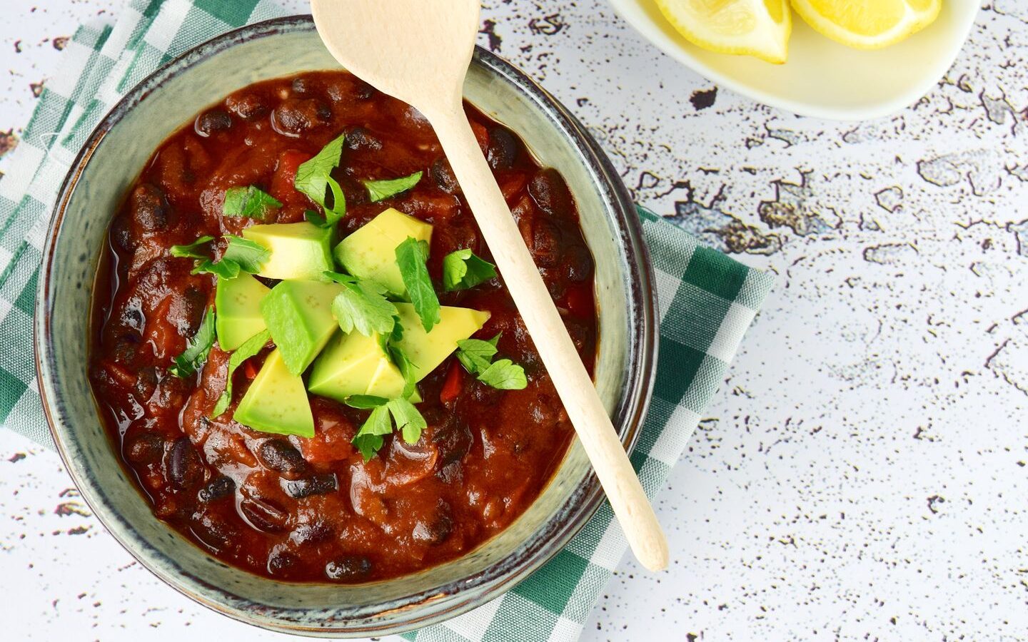 vegan chilli in a bowl topped with avocado and cilantro