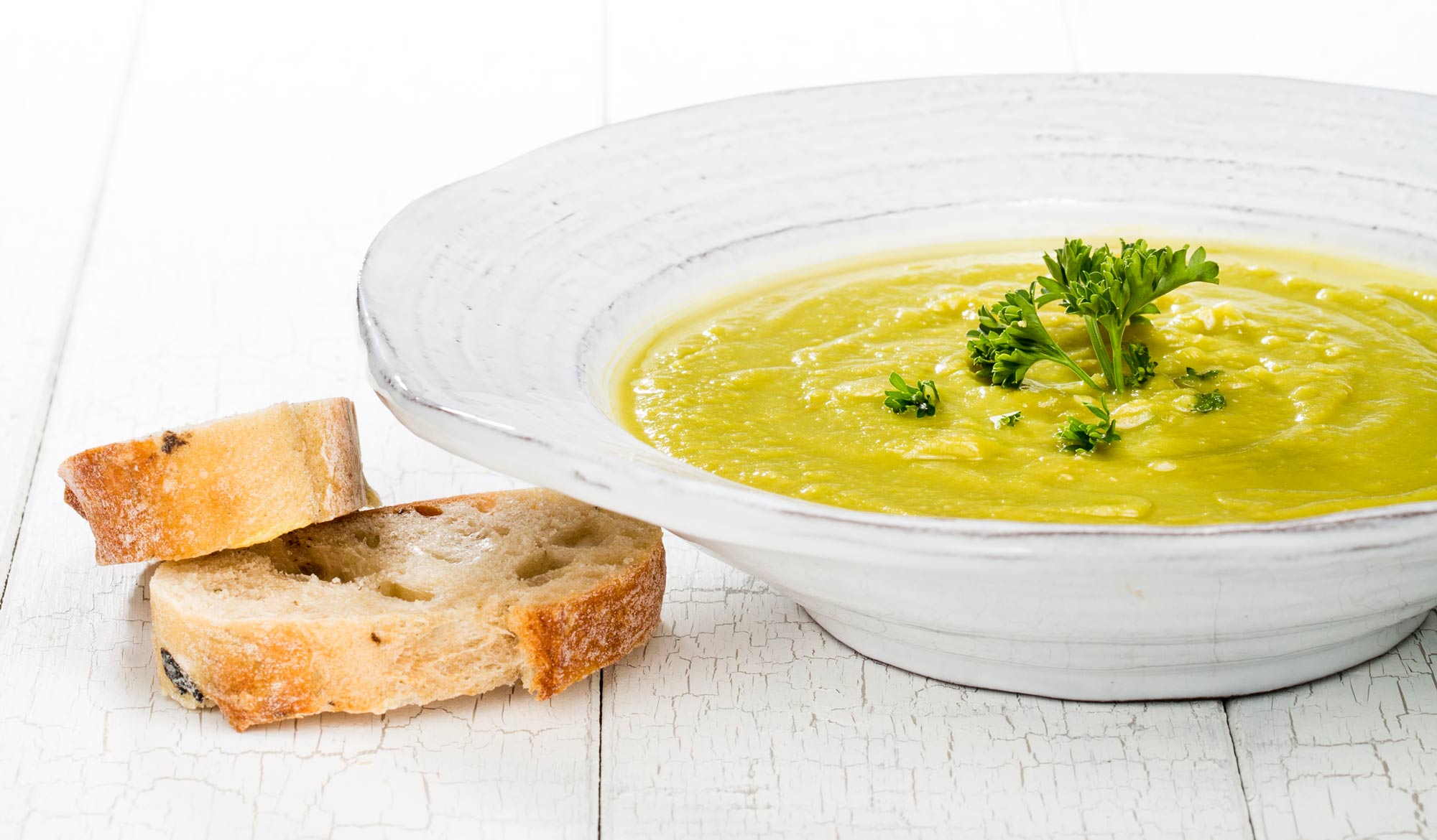 A bowl with a thick pea soup and bread