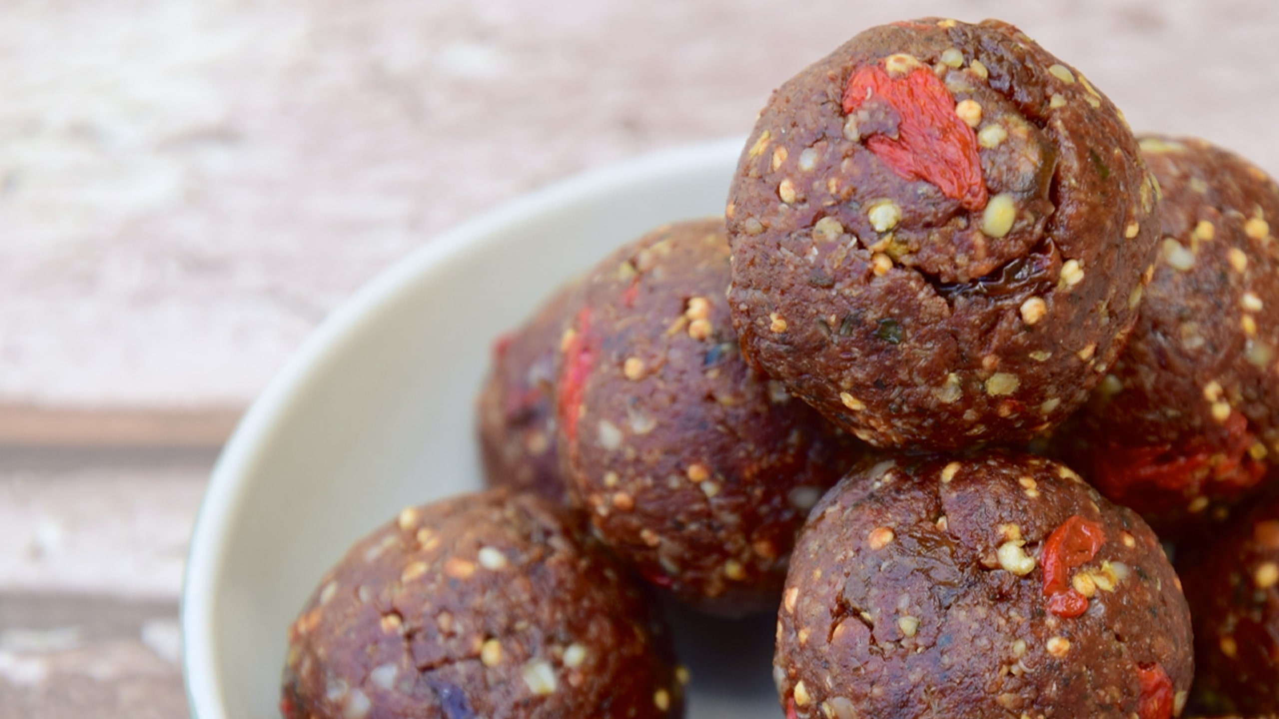 raw truffle balls with goji berries in a pile on a plate