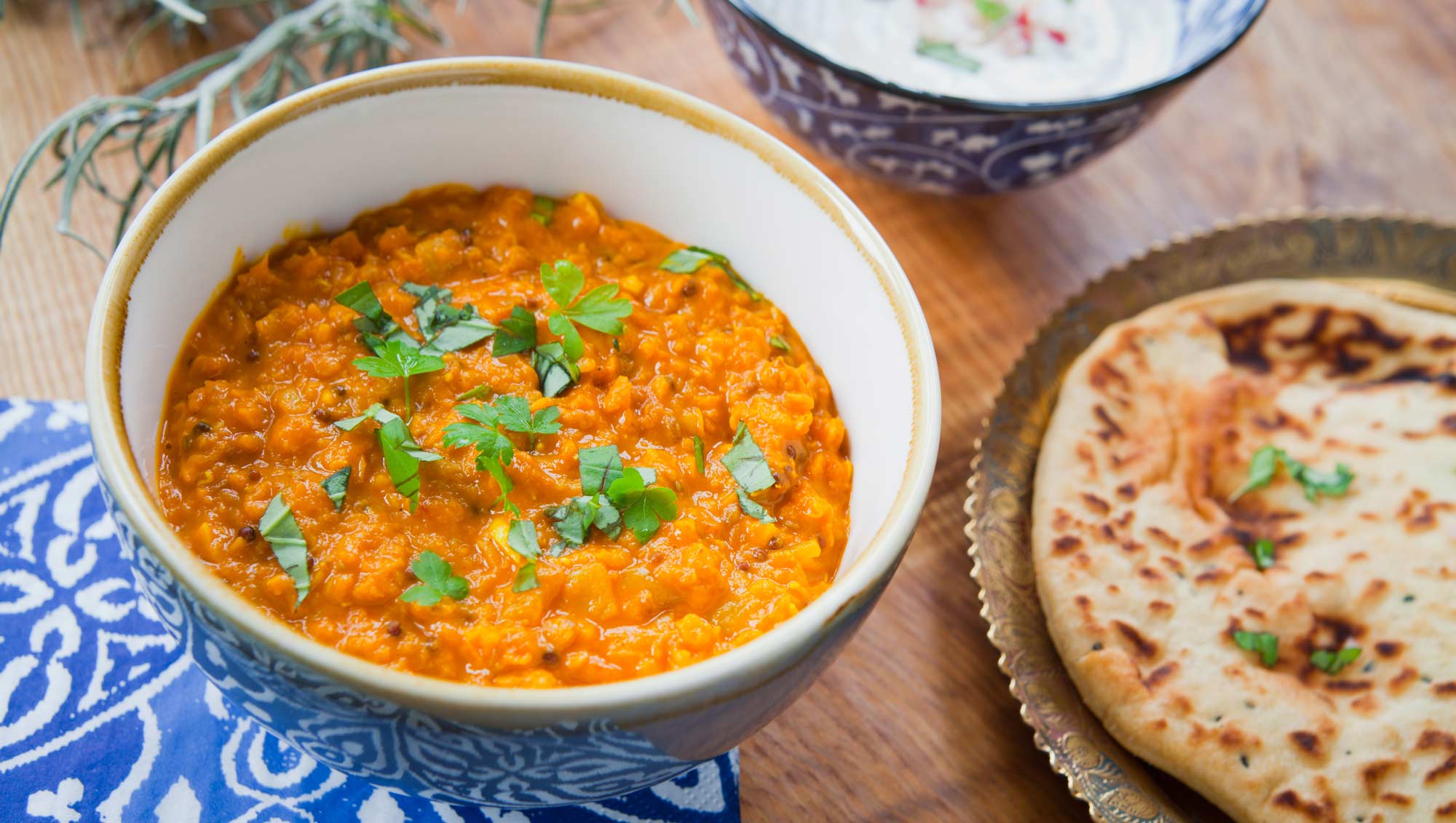 red lentil dal in a bowl with indian bread