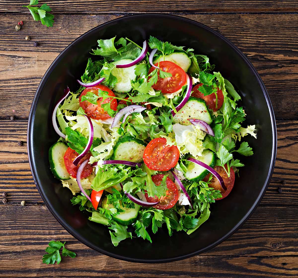 top view of green salad with cherry tomatoes and onion