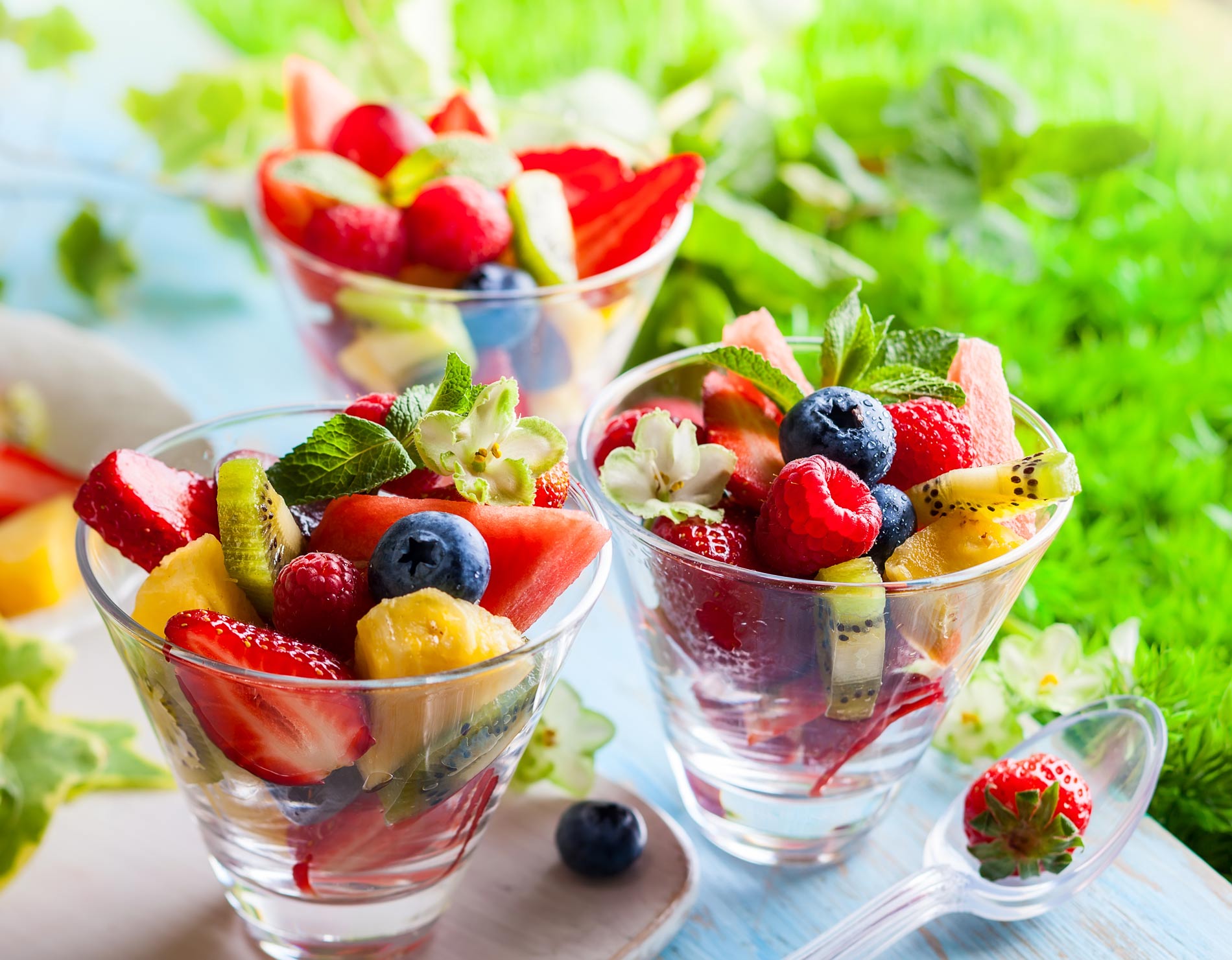 fruit salad in three small clear bowls