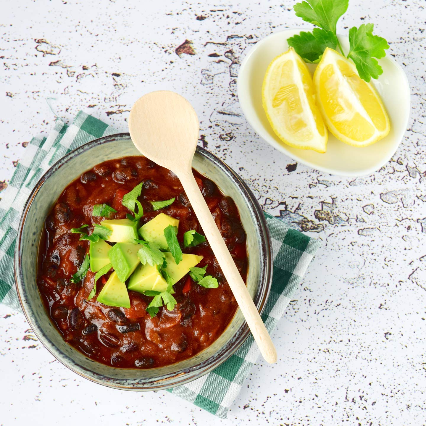 mexican red bean chili in a bowl with avocado and lemon