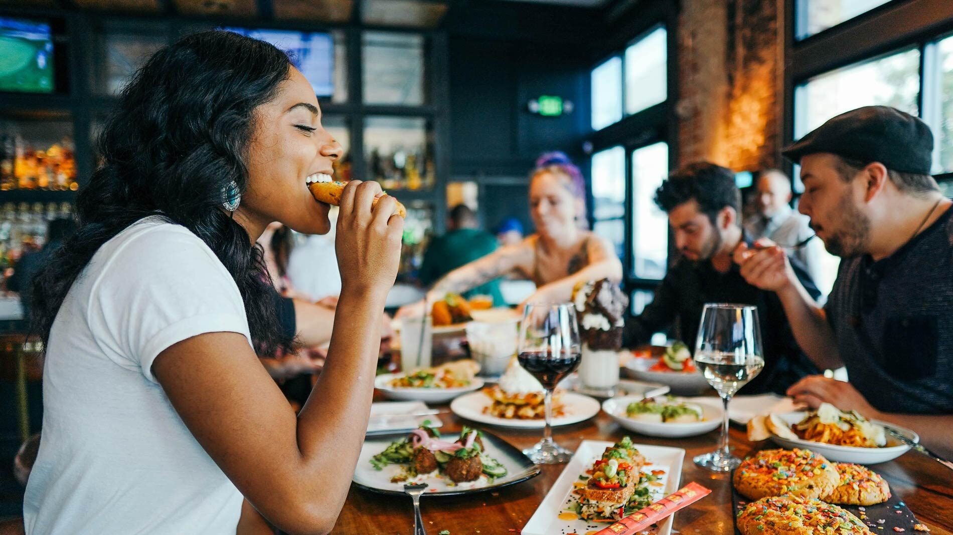 a group of young people eating at a restaurant