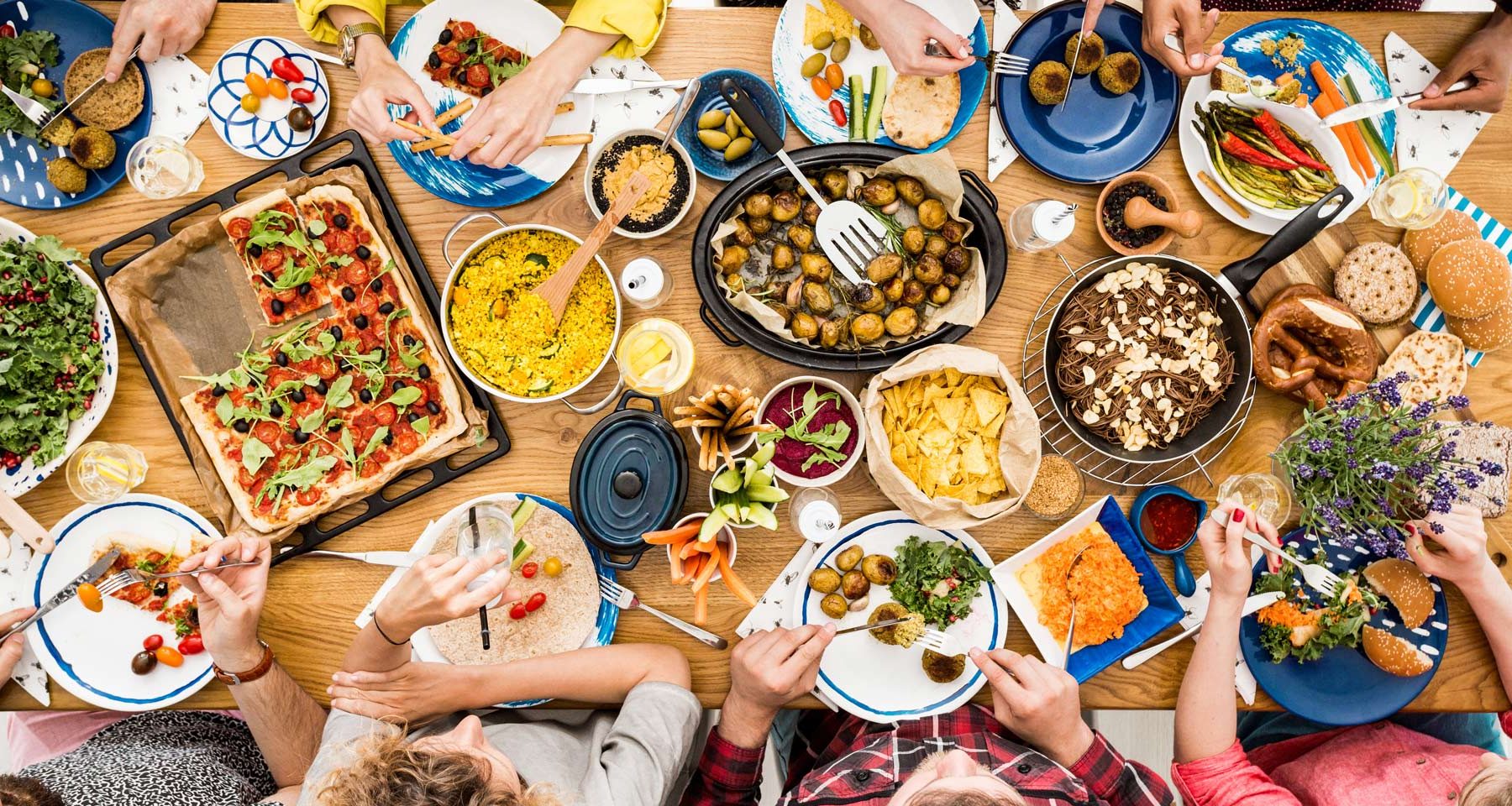 people around dining table share vegan food