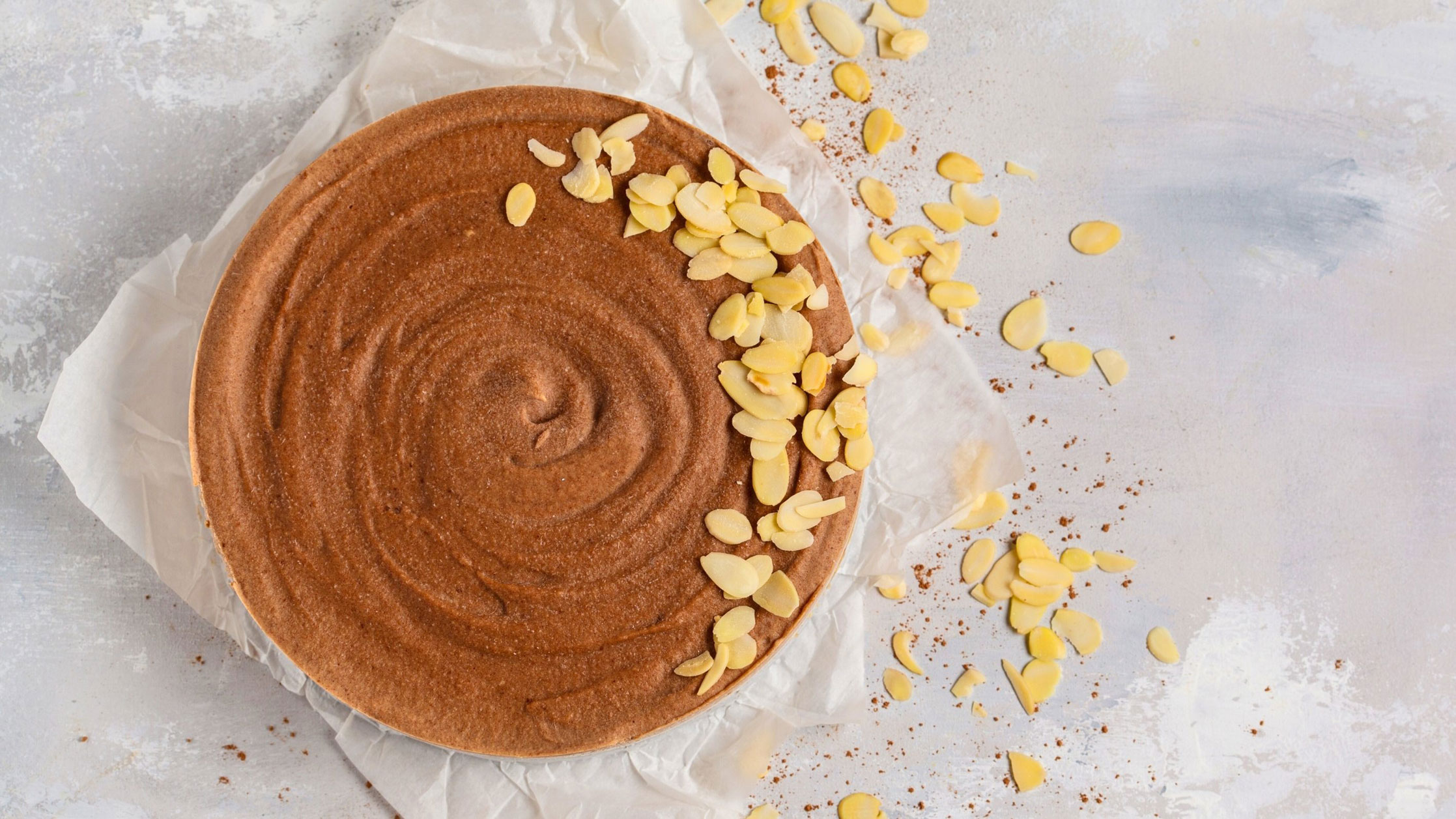 top view of a round cheesecake with Biscoff cookie butter cream and sliced almonds