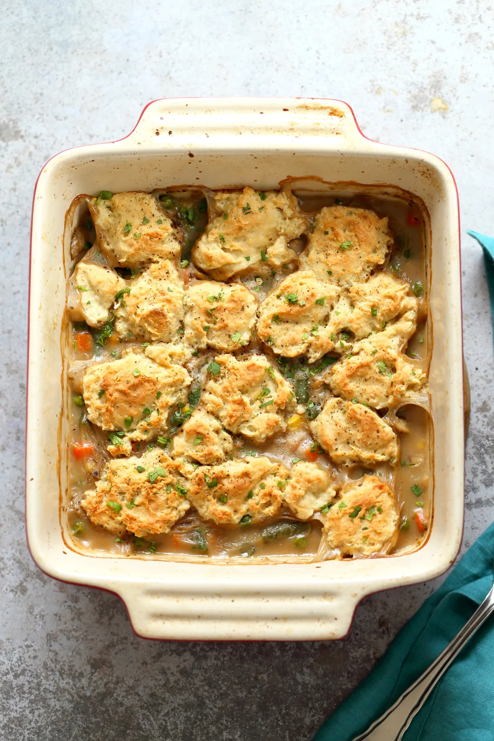 a pan of vegan pot pie topped with biscuits