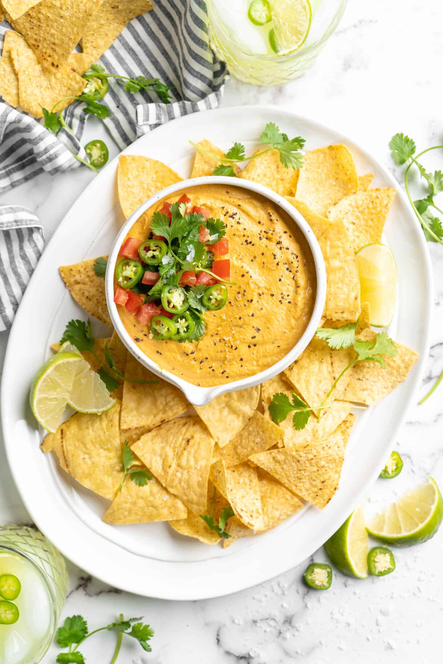 plate of nachos with a bowl of vegan queso in the middle