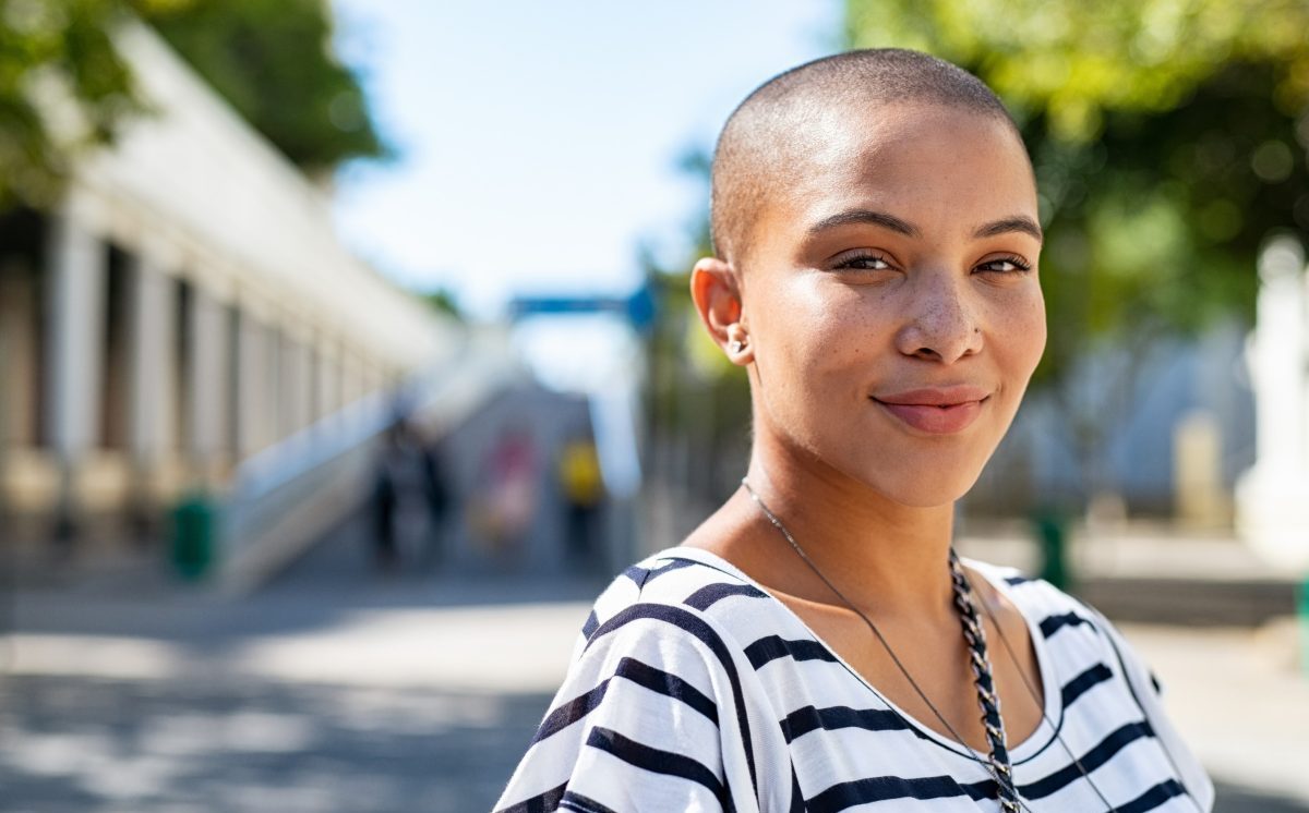 portrait shot of a woman in the street looking straight at the camera and slightly smiling