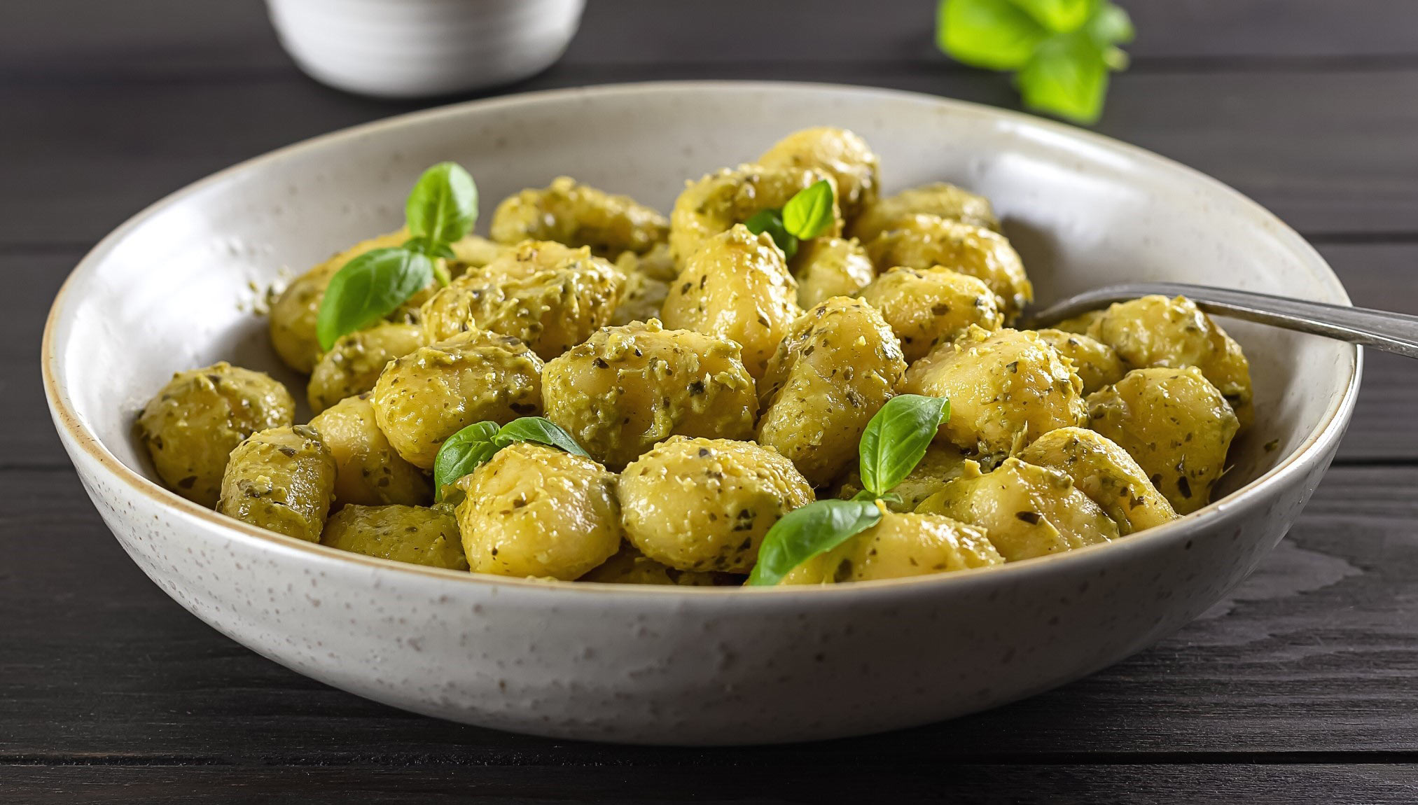 A bowl of gnocchi covered with green sauce made from lamb's lettuce and nuts