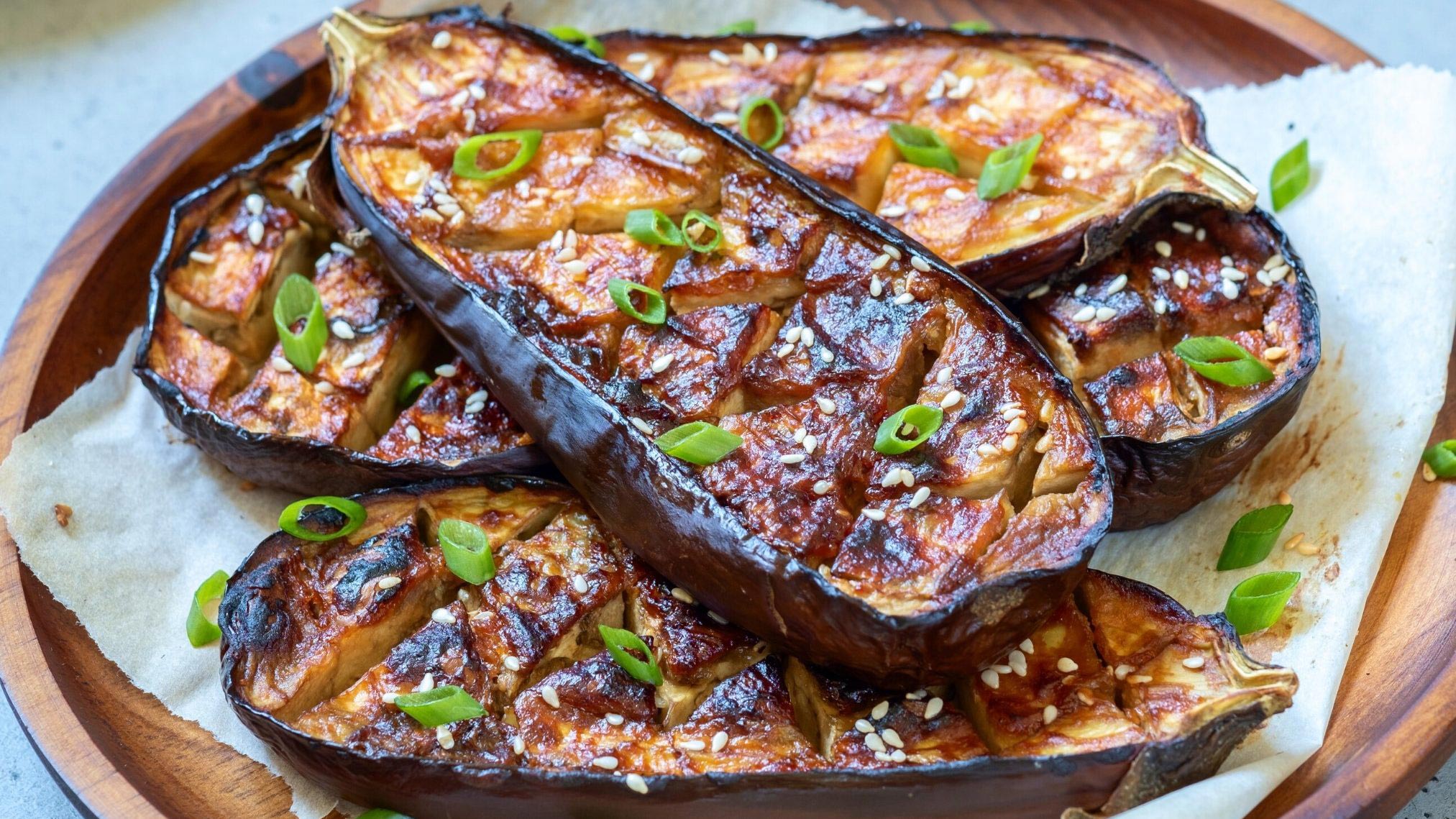 halves of eggplants roasted in brown sauce with spring onions for garnish