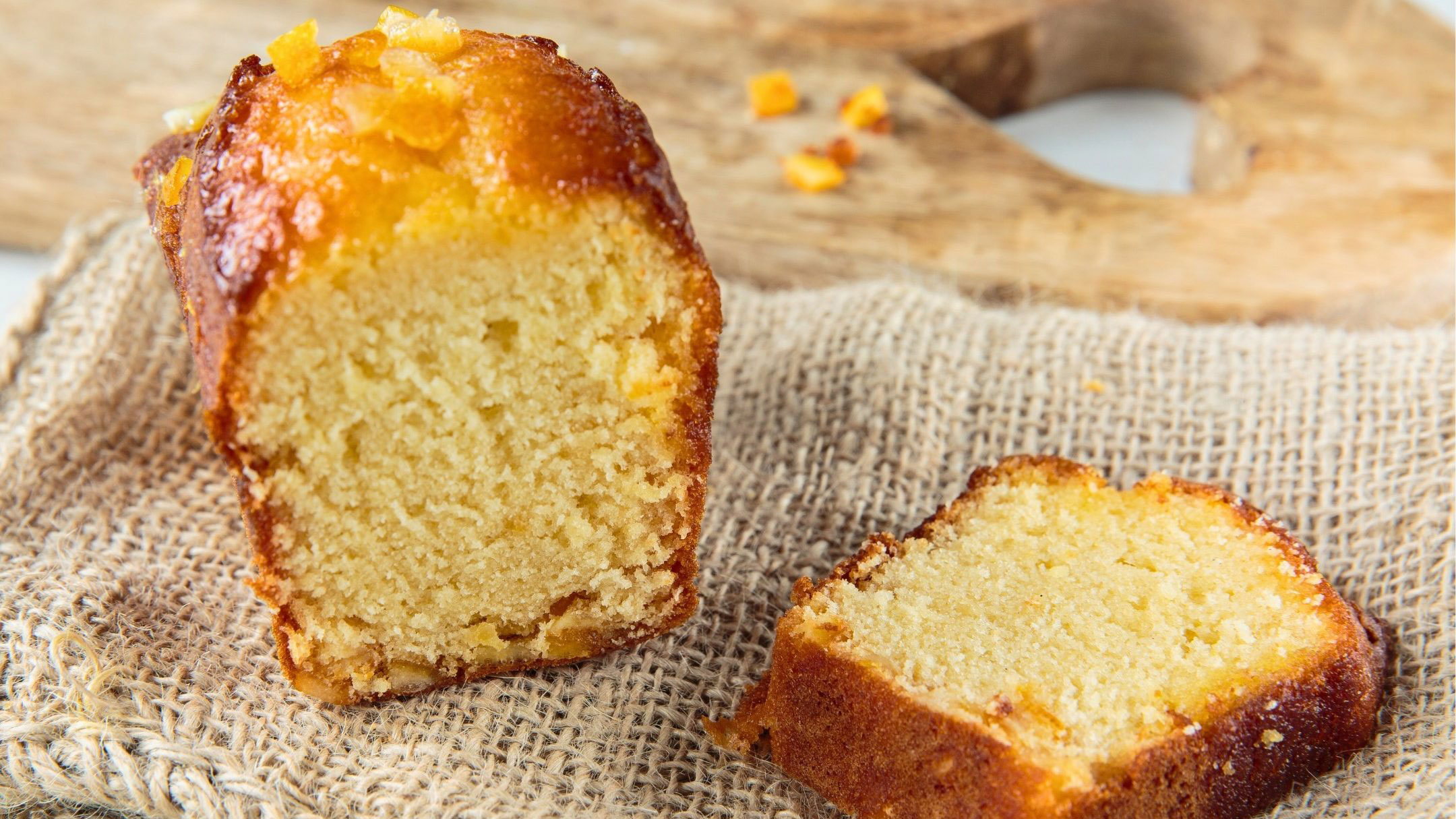 a loaf of orange-sponge cake with slice next to it