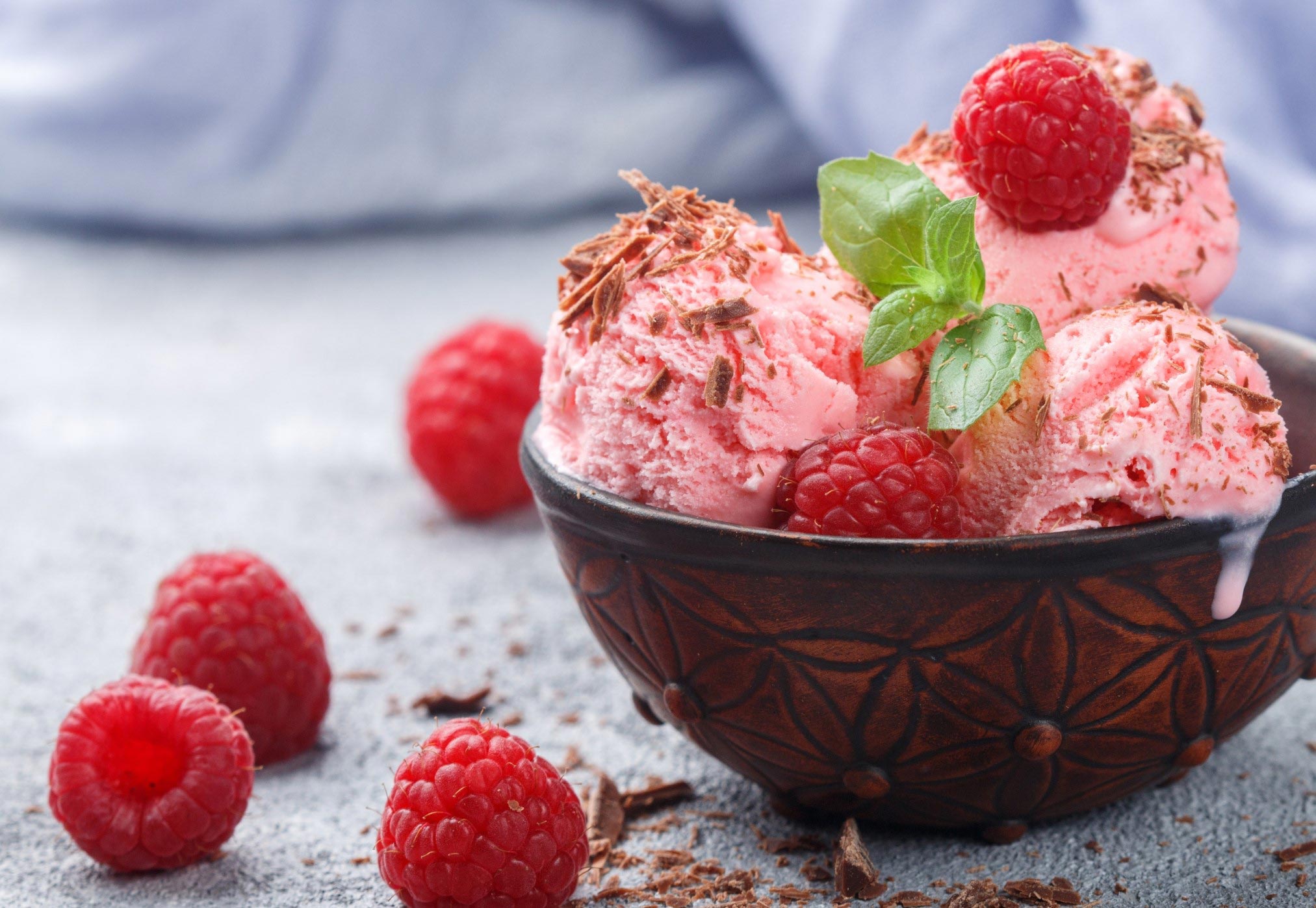 a bowl of homemade vegan raspberry ice cream with fresh raspberries