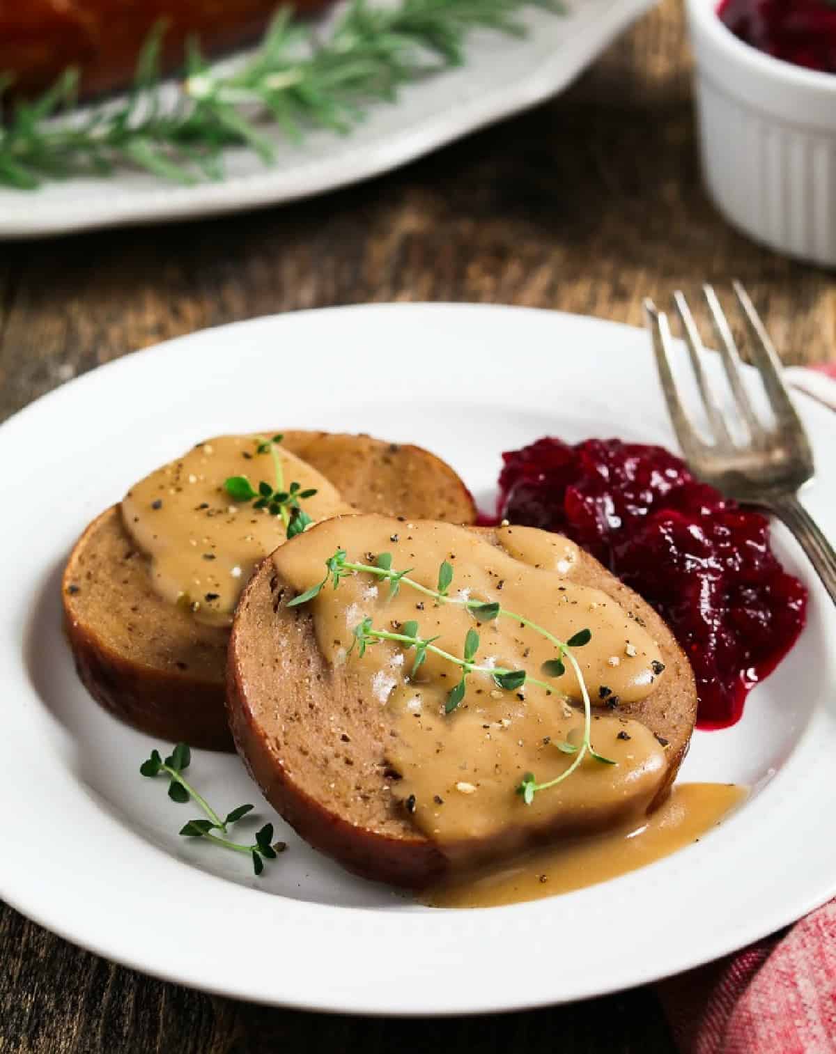 two slices of vegan turkey roast in a plate with gravy